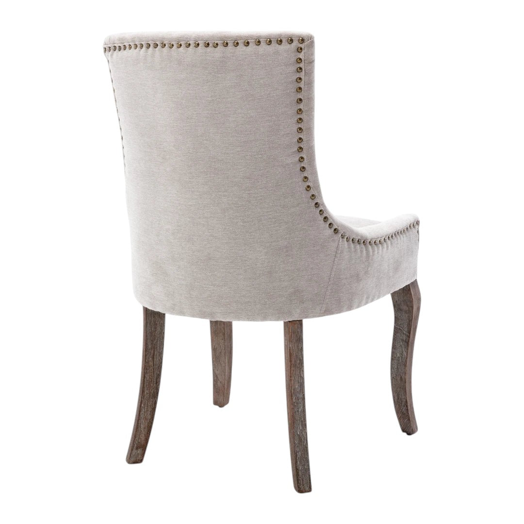 Beige dining chair with bronze nail head trim