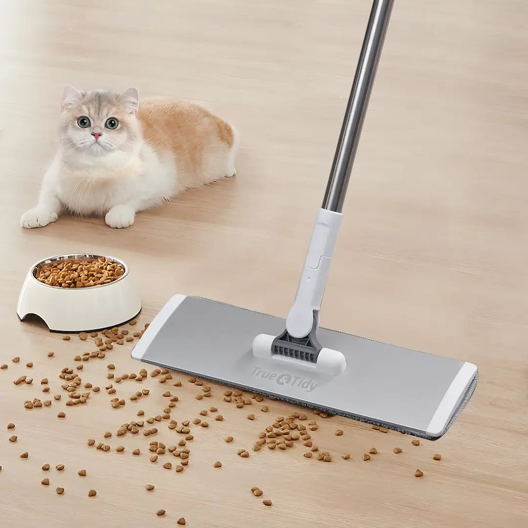 Pet-hair-removeron a wooden floor with a pet mop and a cat in the background.